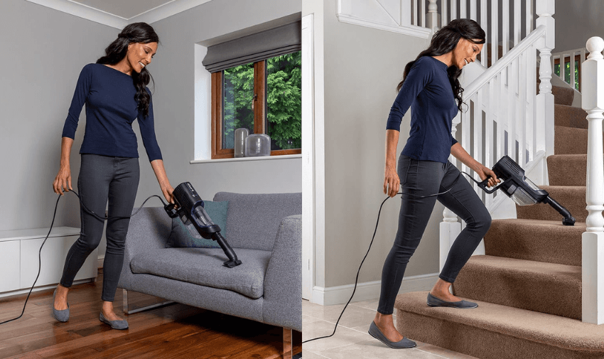 A woman with long dark hair uses a handheld vacuum. In one image, she cleans a gray sofa in a living room. In the other, she vacuums beige carpeted stairs. She's wearing a navy top, grey pants, and slippers.