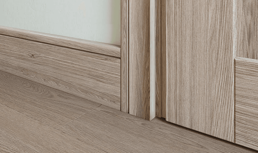 close up on a wooden skirting board against wooden flooring