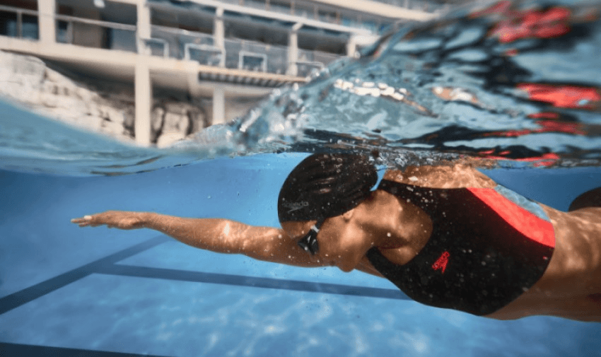 person swimming underwater wearing Speedo swim wear