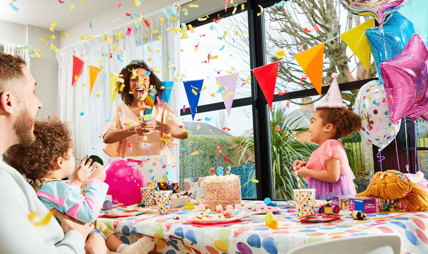 A joyful family celebrating a child's birthday at home with balloons, a decorated cake, and confetti, symbolising the happiness and excitement of special occasions.