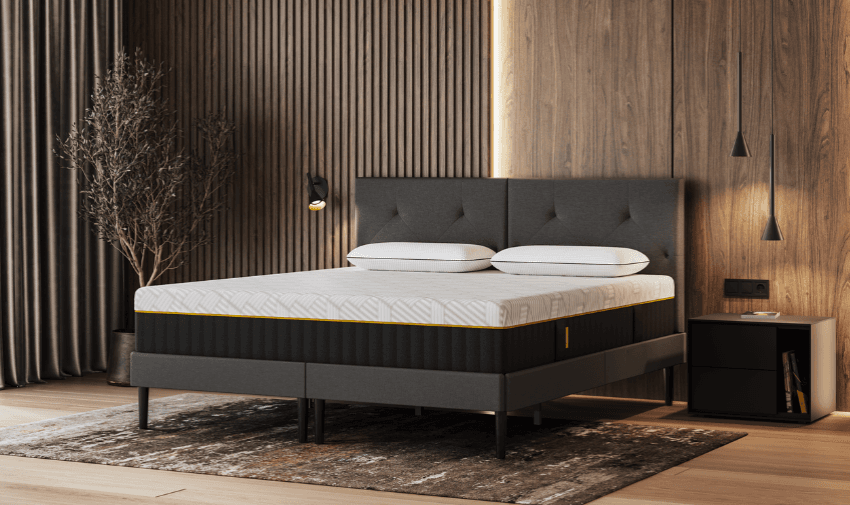 A sleek modern bedroom setup featuring a premium Emma mattress on a dark upholstered bed frame, surrounded by warm wood paneling and minimalist decor. Highlights mobility discounts for the home