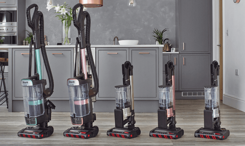  5 different Shark UK vacuums lined up in a kitchen