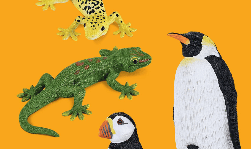 A vibrant image with an orange background displaying toy models of two lizards, a penguin, and a puffin. One lizard is yellow with black spots and the other is green with red markings. The penguin stands tall, while the puffin has a distinctive colourful beak.