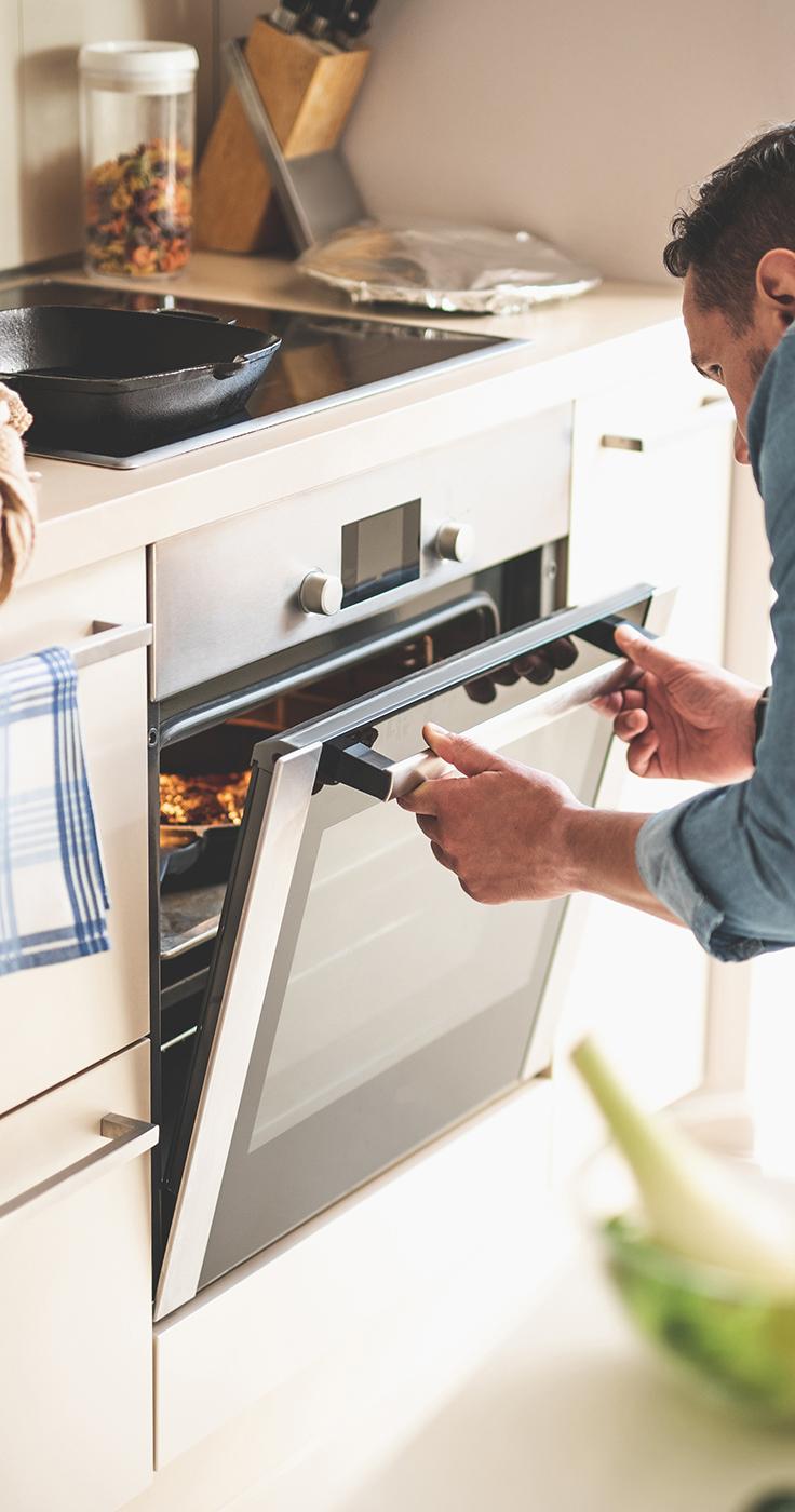 a man closing the oven door