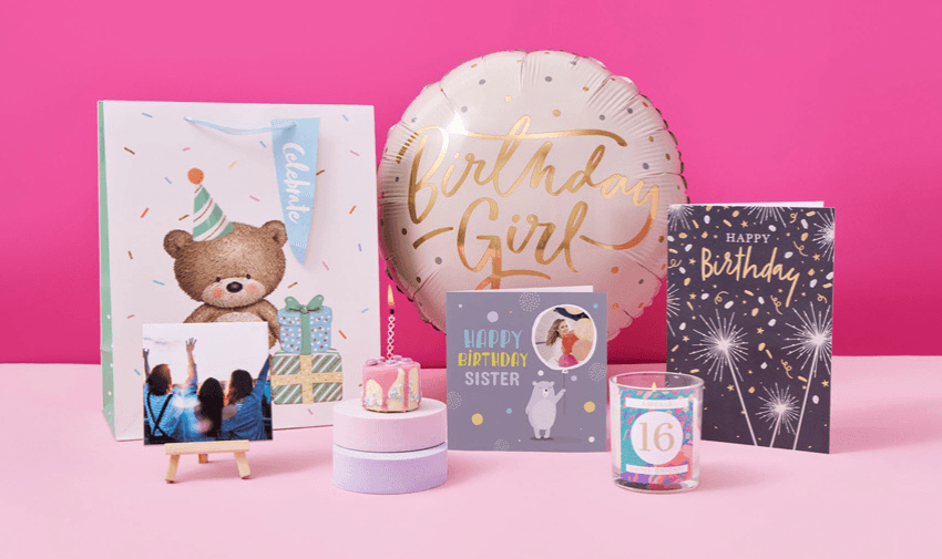 A vibrant display of birthday gift items, including a teddy bear gift bag, balloons, candles, and colourful birthday cards, designed for special moments.