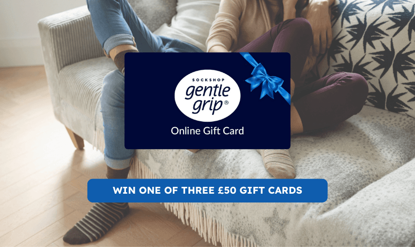 A promotional image featuring the SockShop Gentle Grip online gift card with a blue ribbon, placed over a cosy scene of two people relaxing on a sofa. Highlighting Purpl’s exclusive disabled discounts and a chance to win one of three £50 gift cards for comfortable and adaptive socks in the UK.