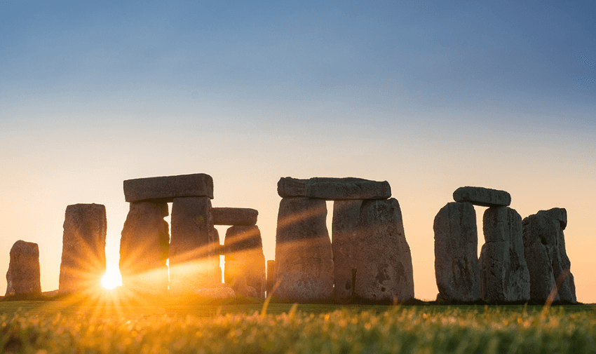 stonehenge with the sun rising through it