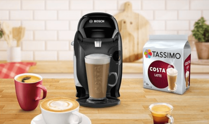 A Bosch Tassimo coffee machine with a Costa latte, surrounded by various coffee drinks and a Tassimo Costa Latte pack. Highlights Shopping Discounts for Disabled People and Kitchen Appliance Offers.