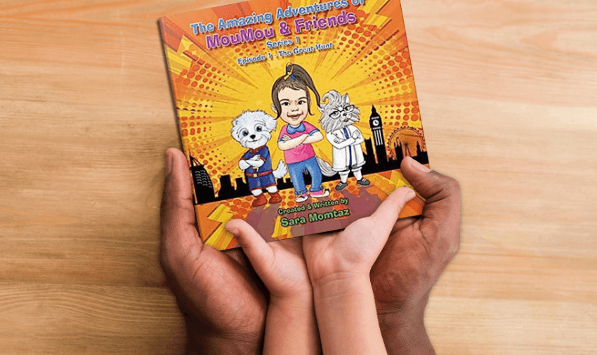 two pairs of hands are holding a colourful children's book titled "The Amazing Adventures of Moolmoo & Friends." The book cover shows illustrated animal characters in various poses against a vibrant backdrop.