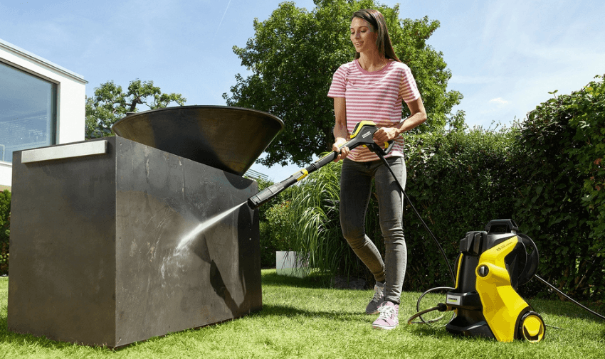 a lady using a Karcher K5 classic pressure washer in the garden