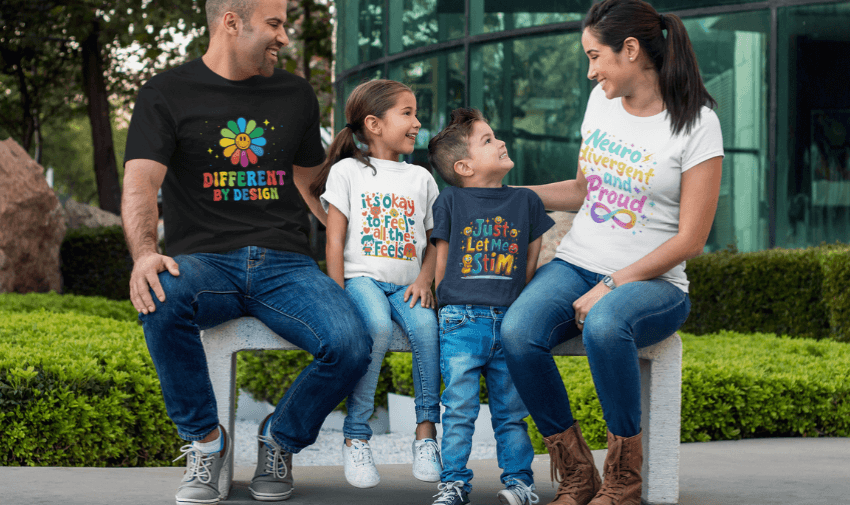 A family of four, sitting on a bench and smiling at each other. Each person wears a colourful t-shirt with positive, inclusive messages. They are outdoors, with greenery and a modern glass building in the background.