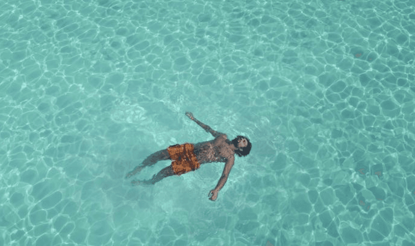 A person relaxing and floating in crystal-clear turquoise water, ideal for EasyJet Holidays' sunny and relaxing getaway offers.