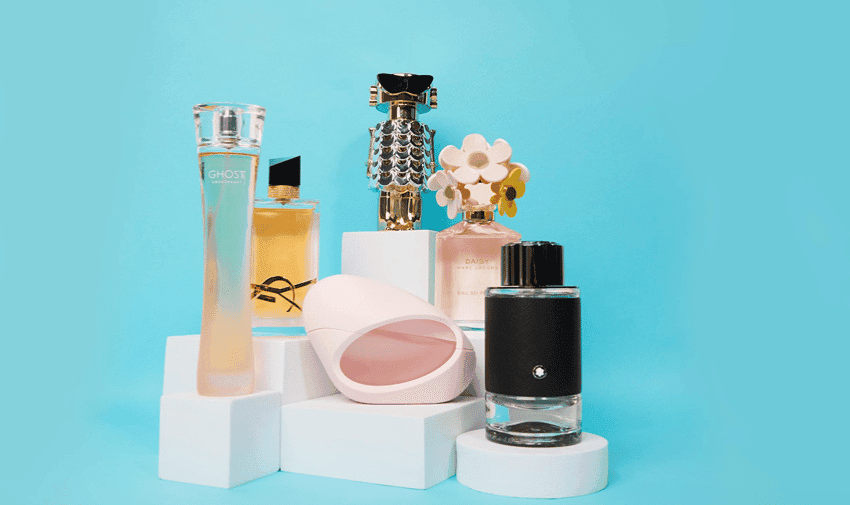 Selection of perfume bottles displayed on white stands with a blue background