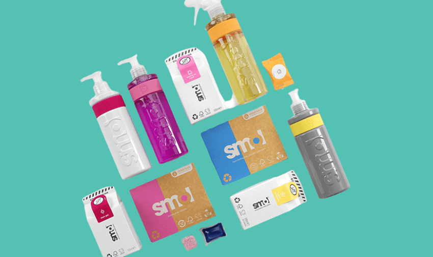 Flat lay of Smol's eco-friendly home care products, including detergents, sprays, and cleaning tablets in vibrant packaging, set against a teal background.