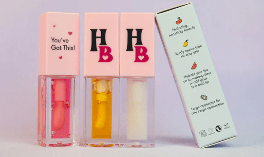 A trio of Human Beauty hydrating lip glosses in elegant square tubes with vibrant shades, promoting an eco-friendly and stylish makeup choice.