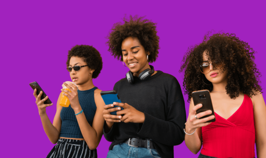 three people looking at their mobile phone screens with a purple background