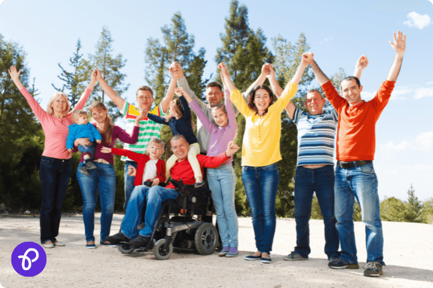 A group of people wearing colourful clothing and holding hands raised in the air