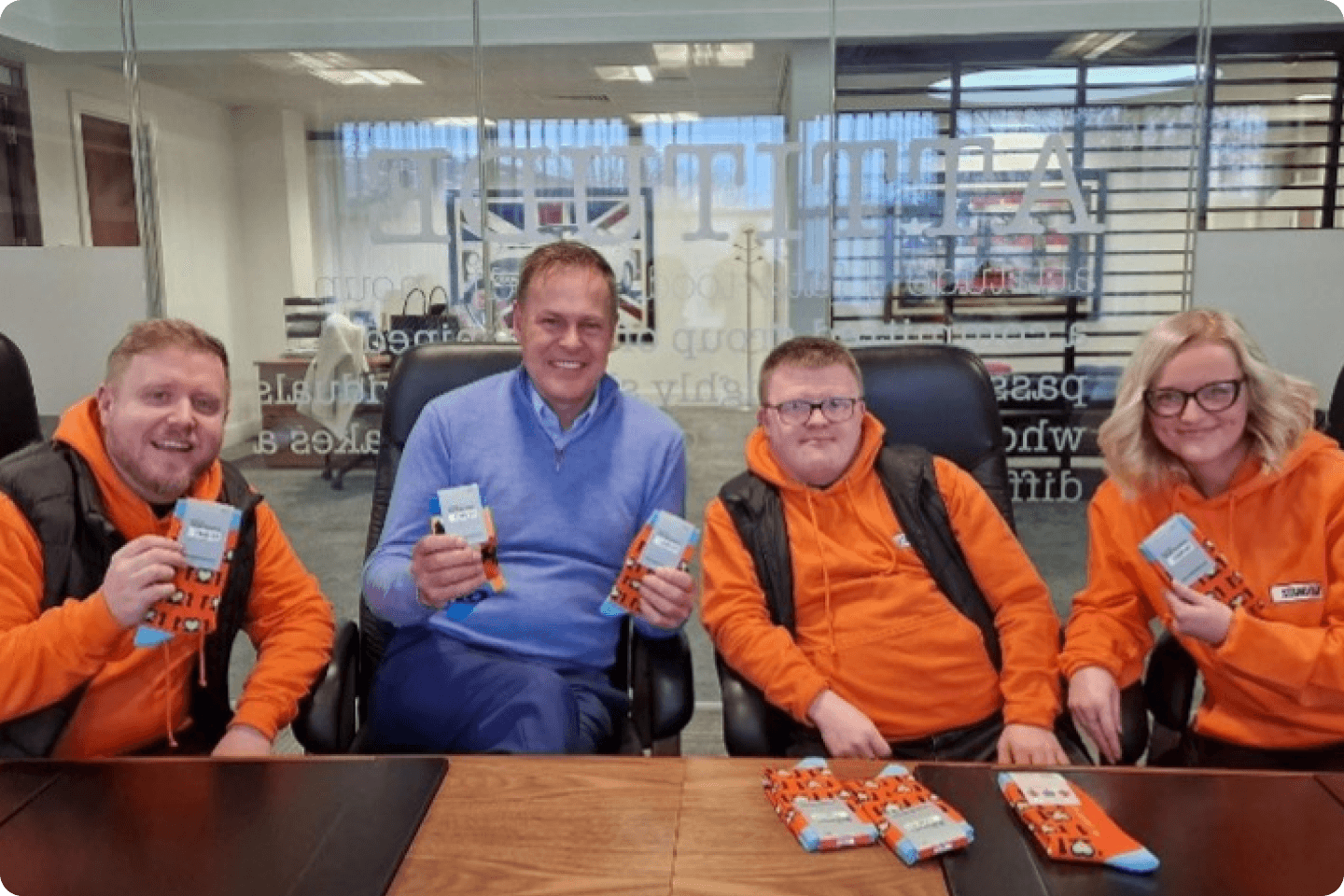 The Stand Out Sock team sitting at a table with Peter Jones