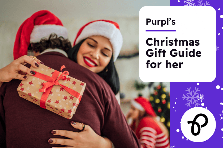 A couple wearing christmas hats are hugging, the woman is facing the camera and is holding a christmas gift in her hand, the text reads Purpl's christmas gift guide for her