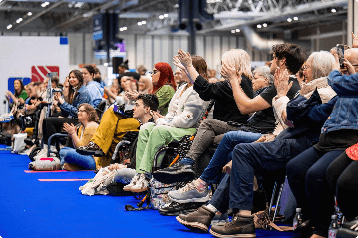 A crowd of disabled people in a seated audience at the Naidex event