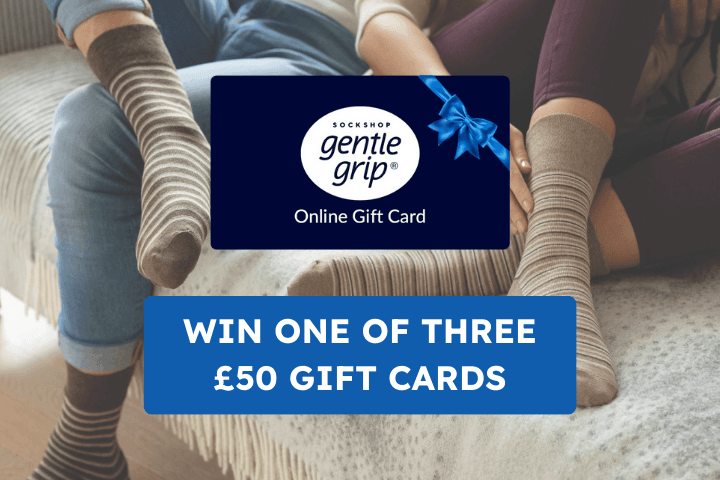 Image shows the bodies of two people relaxing on a sofa wearing Gentle Grip socks, text reads Sockshop Gentle Grip online gft card - win one of three £50 vouchers