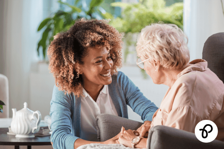 Support worker helping an older disabled woman at home, representing Attendance Allowance rates, eligibility and how to claim financial support for disabilities and long term health conditions in the UK.