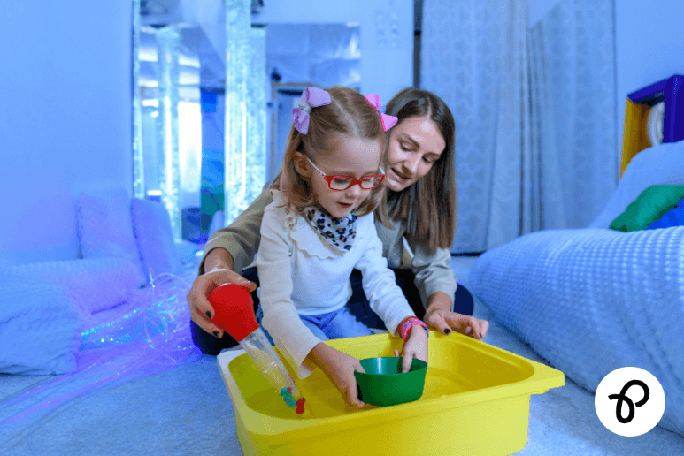 Autistic child using sensory play equipment with support at home highlighting autism support and disabilities in daily life.